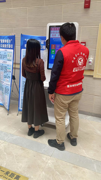 6.市妇幼保健院志愿者指导群众使用自助服务多功能一体机_副本.jpg